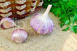 Garlic with burlap and a basket on the board