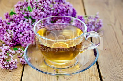 Herbal tea from oregano in a glass cup on board