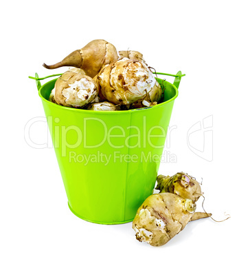 Jerusalem artichokes in a green bucket and on the table