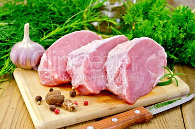 Meat pork slices on a board with oil