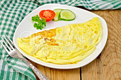 Omelet with vegetables and fork on a board