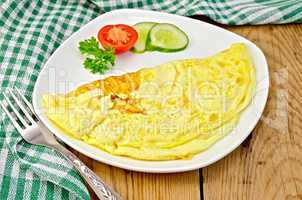 Omelet with vegetables and fork on a board