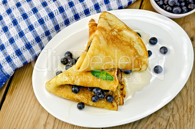 Pancakes with blueberries and honey on the board