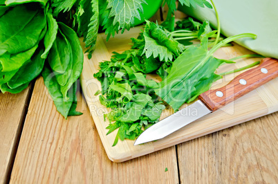 Sorrel and nettles sliced on the board with a knife