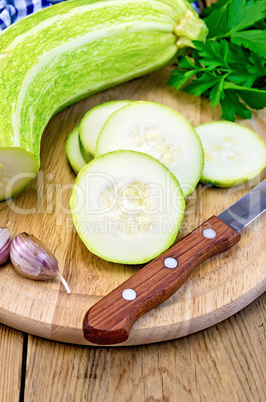 Zucchini green with knife on board