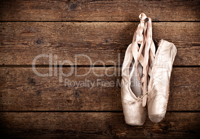 Old used pink ballet shoes hanging