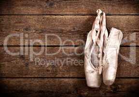 Old used pink ballet shoes hanging