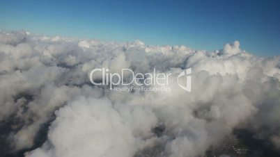 Airplane flying over city and clouds, shot from the window of plane, timelapse