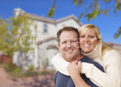 Happy Couple Hugging In Front of House