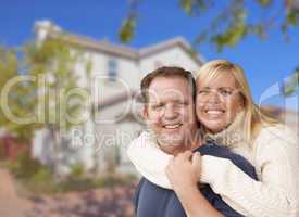 Happy Couple Hugging In Front of House