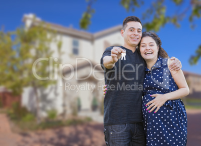 Hispanic Couple with House Keys In Front of New Home
