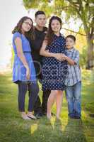 Happy Attractive Hispanic Family With Their Pregnant Mother Outd