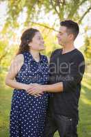 Hispanic Man With His Pregnant Wife Outdoors At the Park