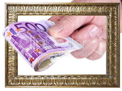 hand holding bundle of money through picture frame