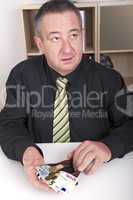 businessman showing the meager contents of his wallet