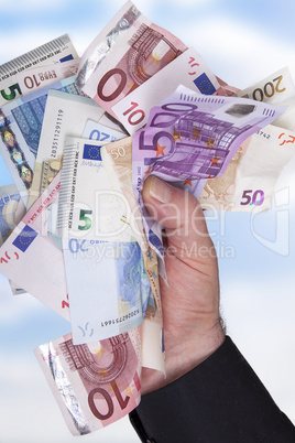 hand holds bunch of crumpled cash