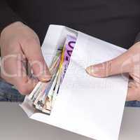 hands holding envelope with cash