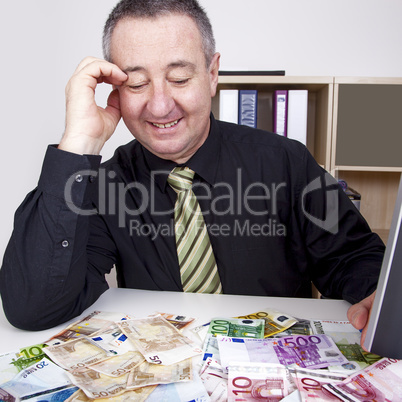 businessman is pleased with his money on the desk