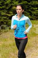 sportive woman running  through meadow