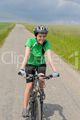 woman riding bike on cycling path meadow