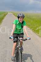 woman riding bike on cycling path meadow