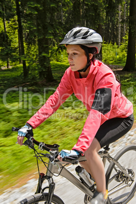 Woman mountain biking in forest motion blur