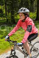 Woman mountain biking in forest motion blur