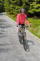 woman riding bike on sunny cycling path