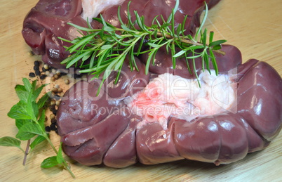 Veal kidneys with herbs over wooden table