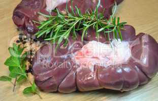 Veal kidneys with herbs over wooden table