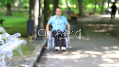 Young man in wheelchair alone in the city park