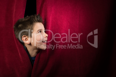 Child appearing beneath the curtain