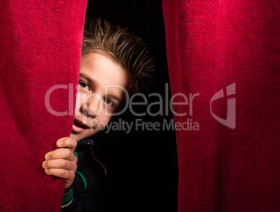 Child appearing beneath the curtain