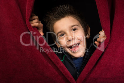 Child appearing beneath the curtain