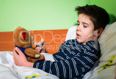Sick child in bed with teddy bear
