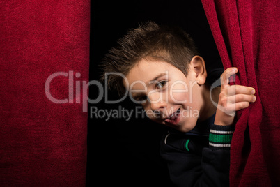 Child appearing beneath the curtain