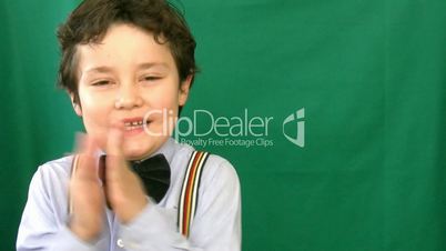 Boy clapping in front of a green screen