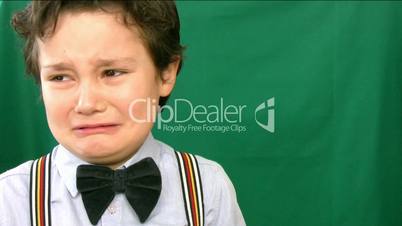 boy crying  in front of a green screen