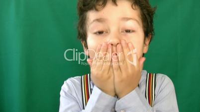 Little boy screaming in front of a green screen