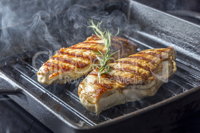 chicken breast with rosemary in pan