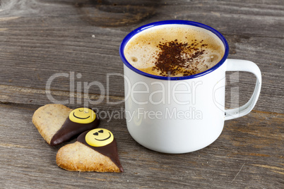 becher mit kaffee und zwei kekse mit smiley gesicht
