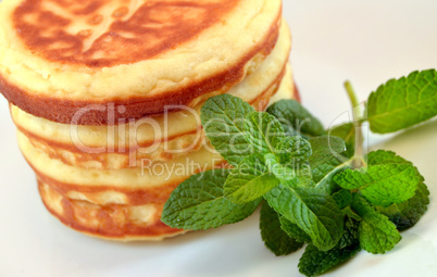 Pancakes with candied cherries and mint leaves