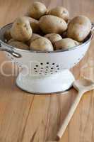 rohe kartoffeln in einem weißen seiher