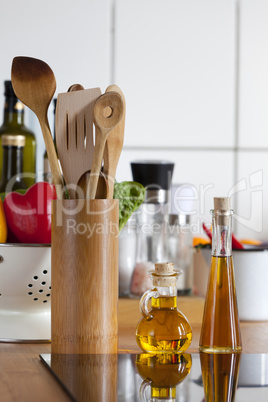 kochlöffel und ölflaschen am kochfeld in küche