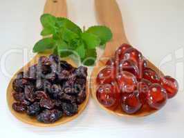 Candied cherries and raisins on wooden spoons