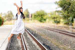 young girl leaping off a train station platform