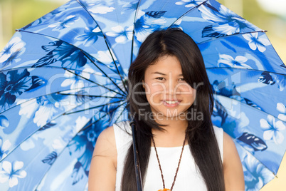 beautiful young thai girl under a blue sunshade