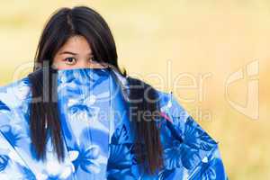 playful young girl peeking over her umbrella