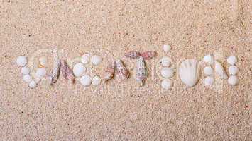 title "vacation" from sea shells with coral sand