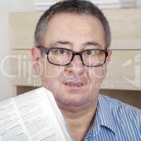 man with glasses reading newspaper